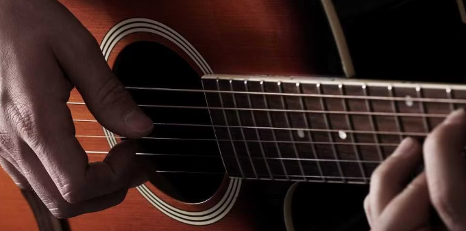 mão de uma pessoa tocando violão